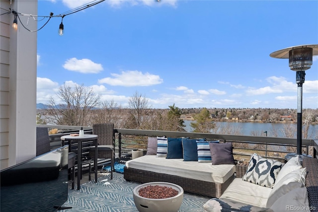 wooden deck with outdoor lounge area and a water view