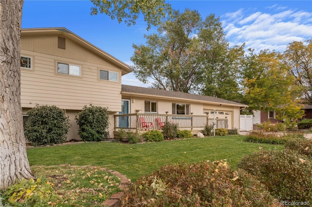 back of property featuring a yard and a deck