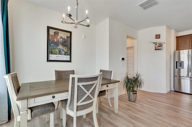 dining area with a chandelier and light hardwood / wood-style flooring