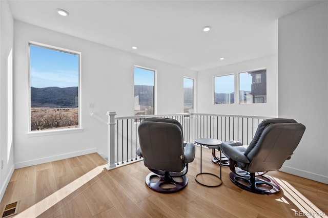 15606 W Girard Ave, Morrison, CO 80465 - sitting room featuring baseboards, visible vents, an upstairs landing, and wood finished floors