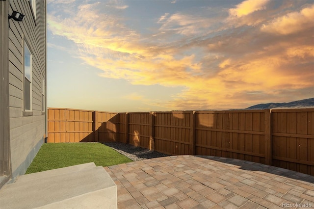 15606 W Girard Ave, Morrison, CO 80465 - patio terrace at dusk featuring a fenced backyard and a lawn