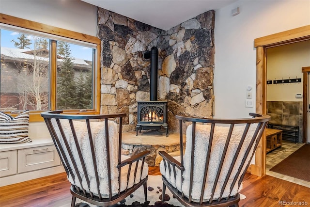 living area with wood-type flooring and a wood stove