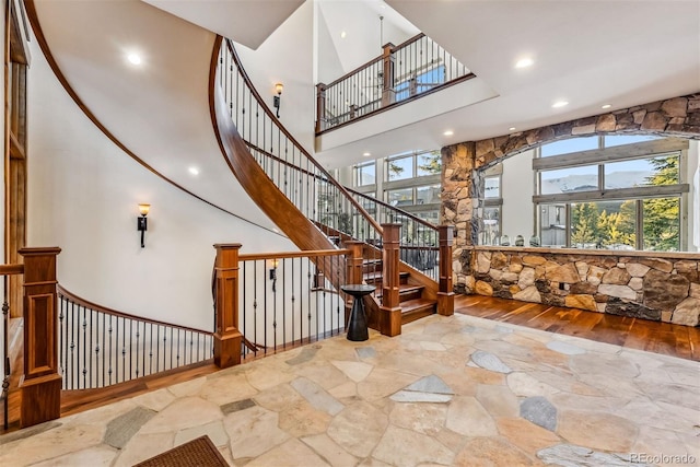 stairway featuring a high ceiling and hardwood / wood-style floors