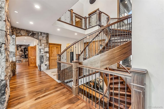 staircase featuring a high ceiling and wood-type flooring