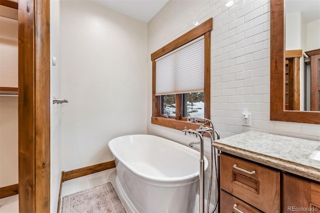 bathroom with a bath, tile walls, tile patterned flooring, and vanity