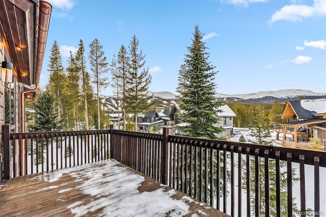 snow covered deck with a mountain view