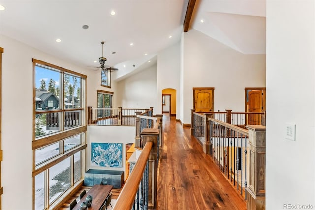 corridor featuring hardwood / wood-style flooring, high vaulted ceiling, and beam ceiling