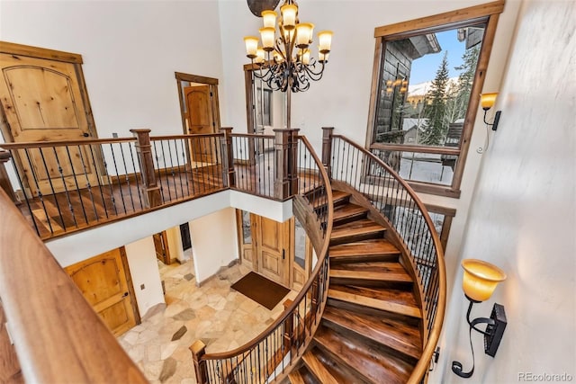 stairway featuring a high ceiling and an inviting chandelier