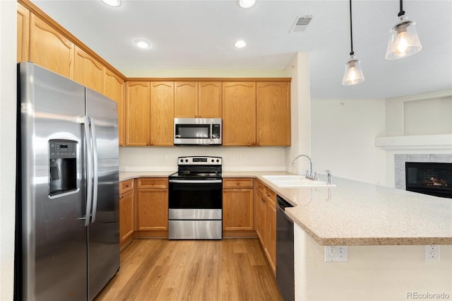 8427 S Hoyt Way Unit 203, Littleton, CO 80128 - kitchen with appliances with stainless steel finishes, a peninsula, light wood-style floors, light stone countertops, and recessed lighting