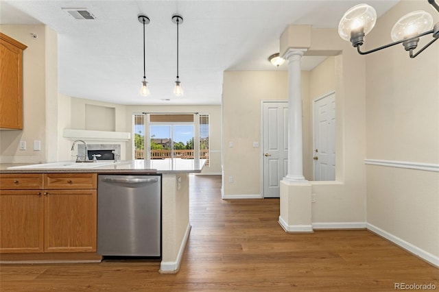 8427 S Hoyt Way Unit 203, Littleton, CO 80128 - kitchen featuring stainless steel dishwasher, light countertops, light wood-type flooring, decorative columns, and pendant lighting
