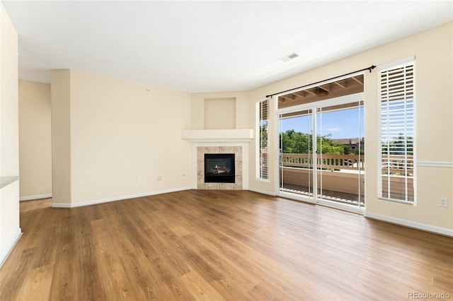 8427 S Hoyt Way Unit 203, Littleton, CO 80128 - unfurnished living room featuring wood finished floors and a tiled fireplace