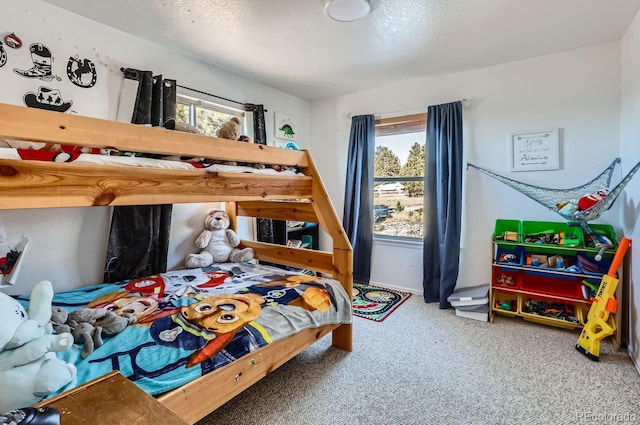 bedroom with carpet floors, multiple windows, and a textured ceiling
