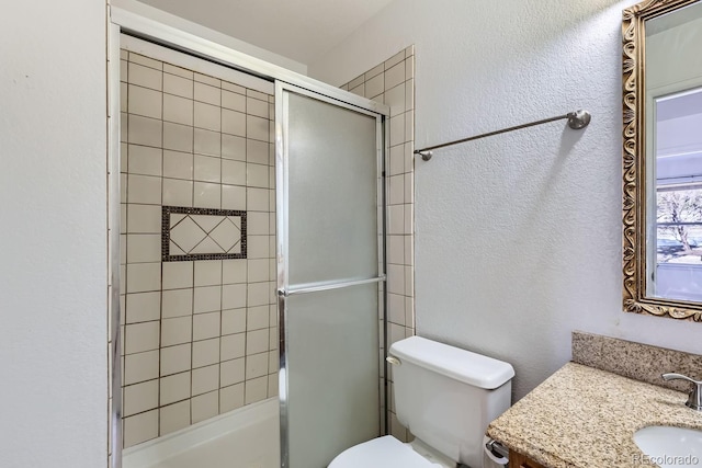 full bath featuring a textured wall, vanity, toilet, and an enclosed shower
