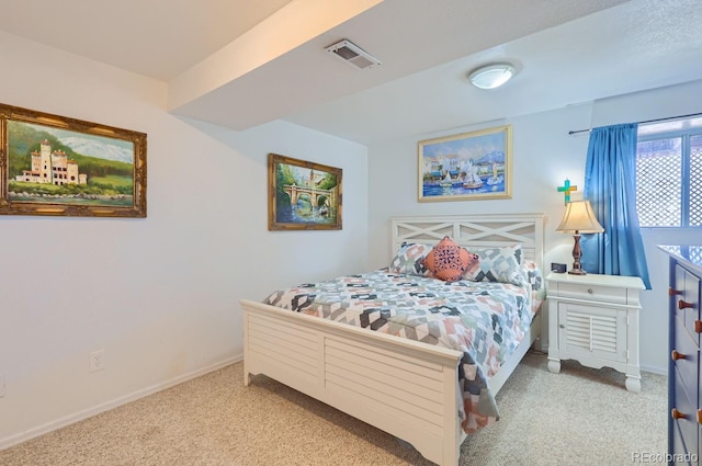 bedroom with visible vents, light carpet, and baseboards