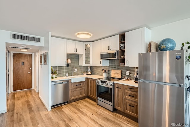 790 N Washington St Unit 1003, Denver, CO 80203 - kitchen featuring stainless steel appliances, light countertops, white cabinets, open shelves, and tasteful backsplash