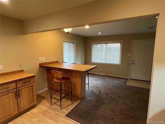 220 Lily Ln, Golden, CO 80403 - kitchen with butcher block countertops, a kitchen bar, brown cabinetry, and a peninsula