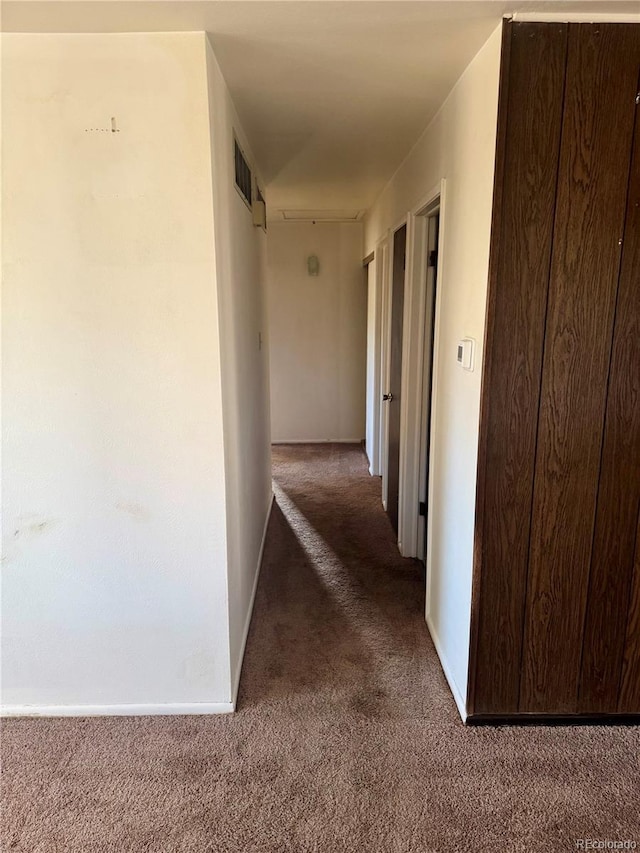 corridor featuring dark colored carpet