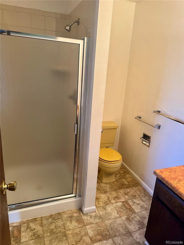 bathroom with vanity, a shower with shower door, and toilet