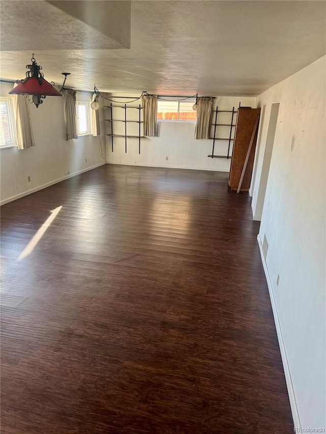 empty room with dark wood-type flooring and a wealth of natural light