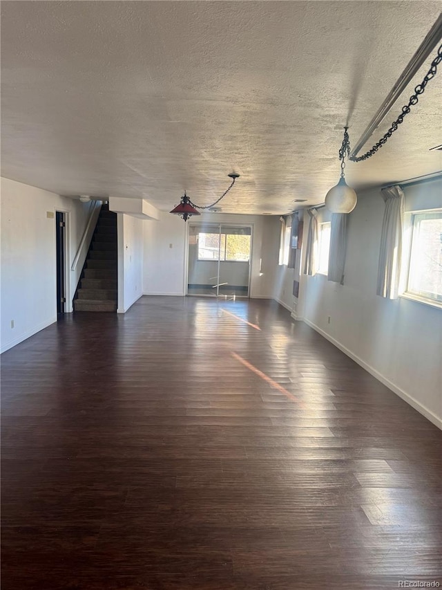 spare room featuring a textured ceiling and dark wood-type flooring