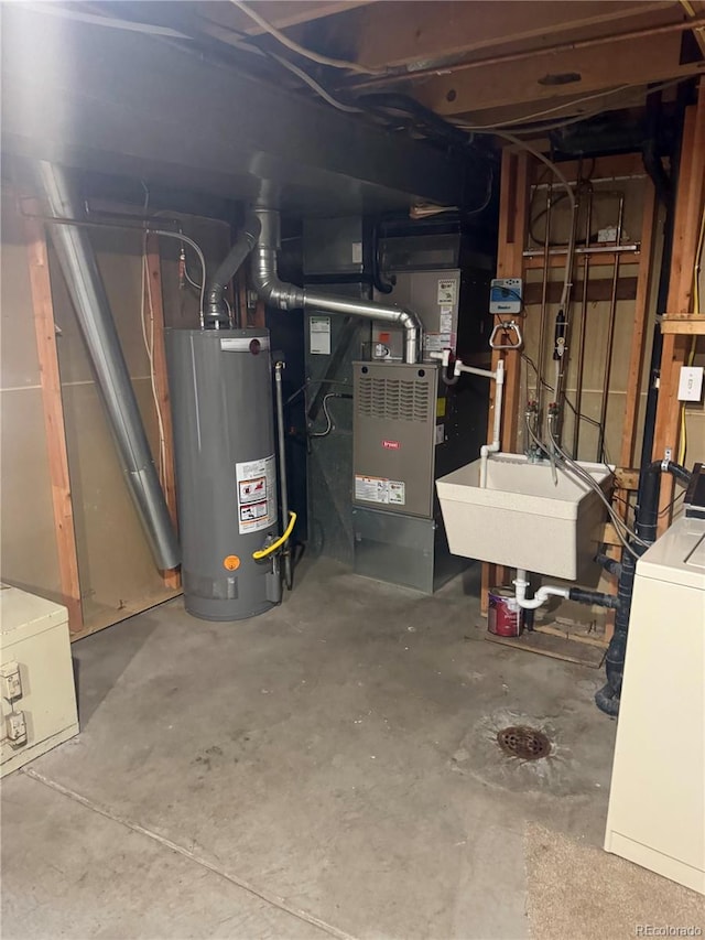 basement with washer / dryer, gas water heater, heating unit, and sink