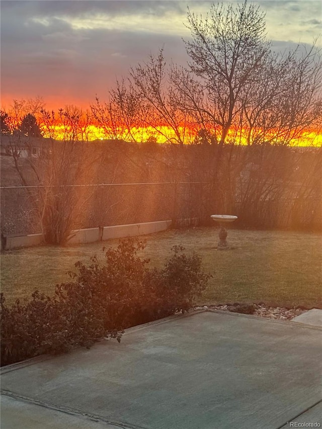 yard at dusk featuring a patio