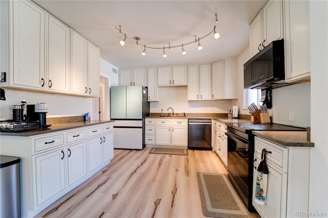 701 Tucson, Aurora, CO 80011 - kitchen with black appliances, light wood finished floors, white cabinets, a sink, and dark stone countertops