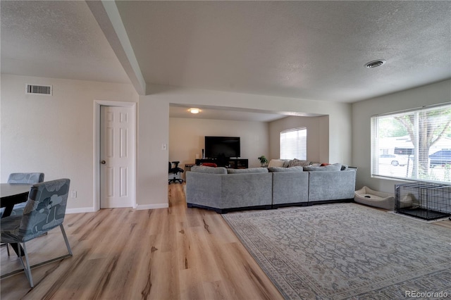 701 Tucson, Aurora, CO 80011 - living room featuring light wood-style floors, a textured ceiling, and baseboards