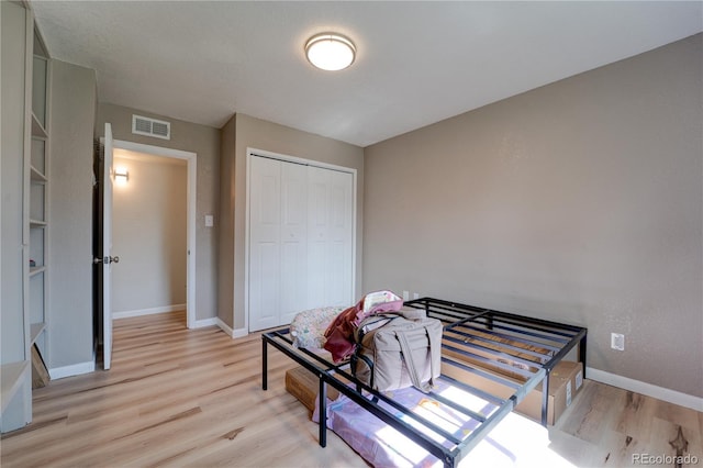 701 Tucson, Aurora, CO 80011 - bedroom with light wood-style floors, baseboards, and a closet