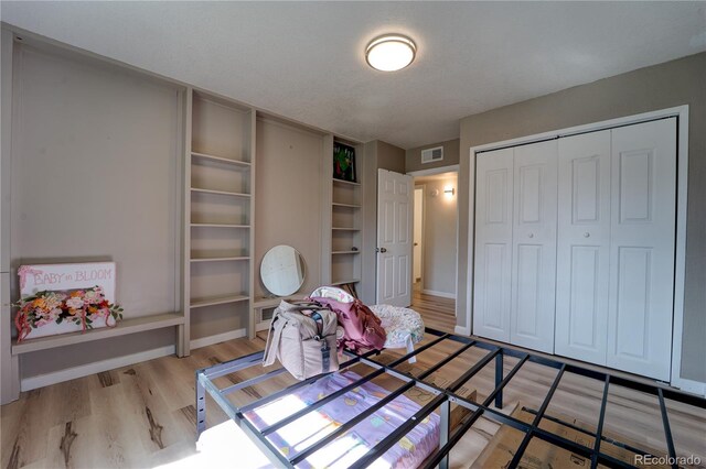701 Tucson, Aurora, CO 80011 - bedroom with light wood-style flooring, a closet, and baseboards