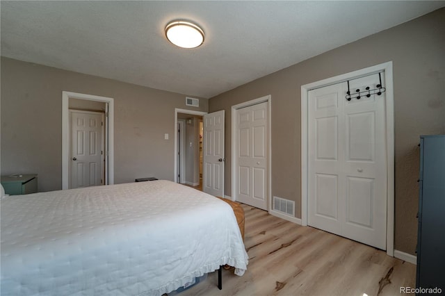 701 Tucson, Aurora, CO 80011 - bedroom with multiple closets, light wood finished floors, and baseboards