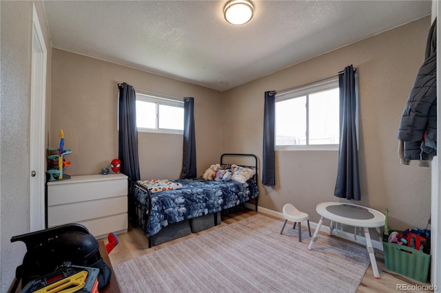 701 Tucson, Aurora, CO 80011 - bedroom with light wood finished floors and a textured ceiling