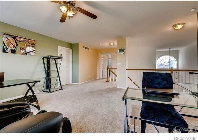 carpeted living room with ceiling fan