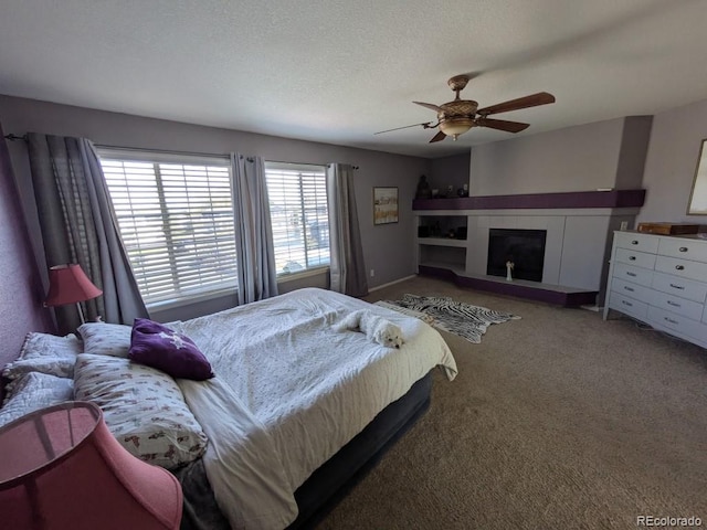 bedroom with a textured ceiling, carpet floors, and ceiling fan