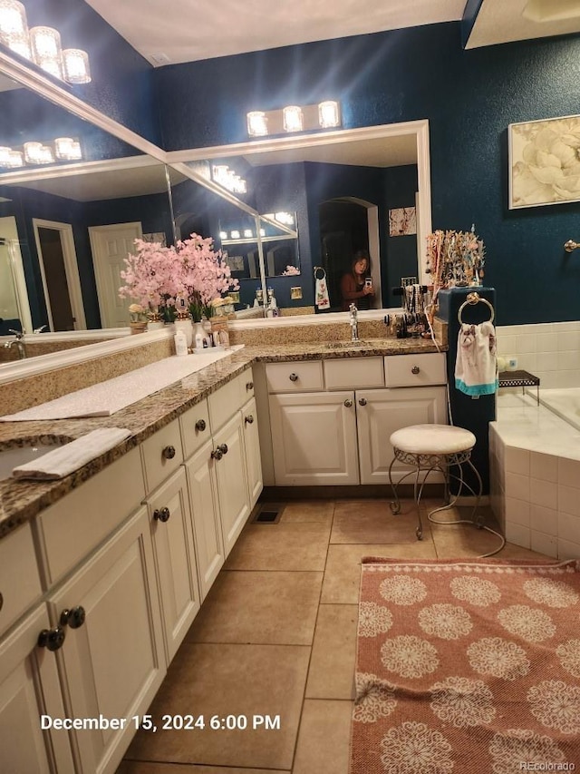 bathroom with vanity, a relaxing tiled tub, and tile patterned floors