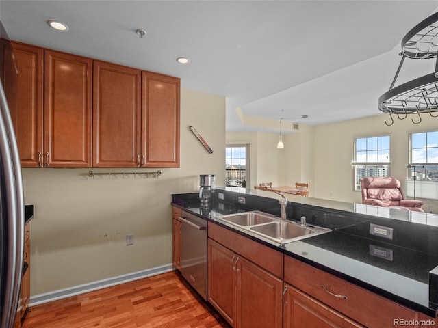 kitchen featuring plenty of natural light, light wood-type flooring, appliances with stainless steel finishes, and a sink