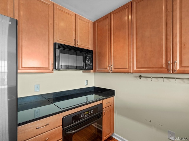 kitchen with dark countertops, black appliances, and built in study area