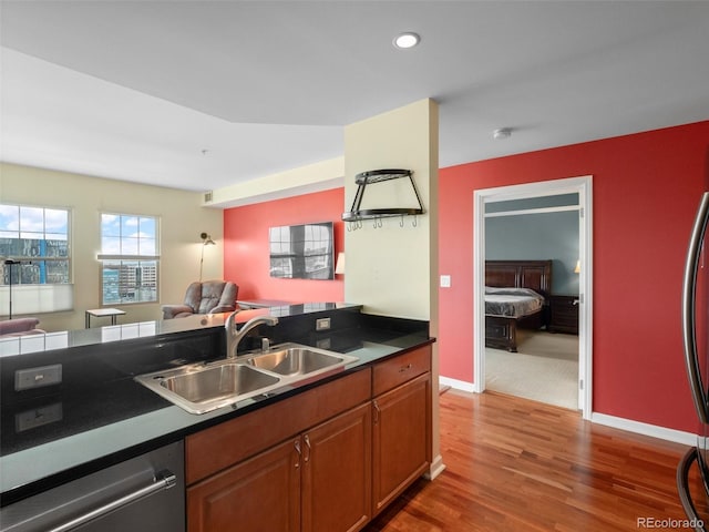 kitchen with dark countertops, open floor plan, appliances with stainless steel finishes, and a sink