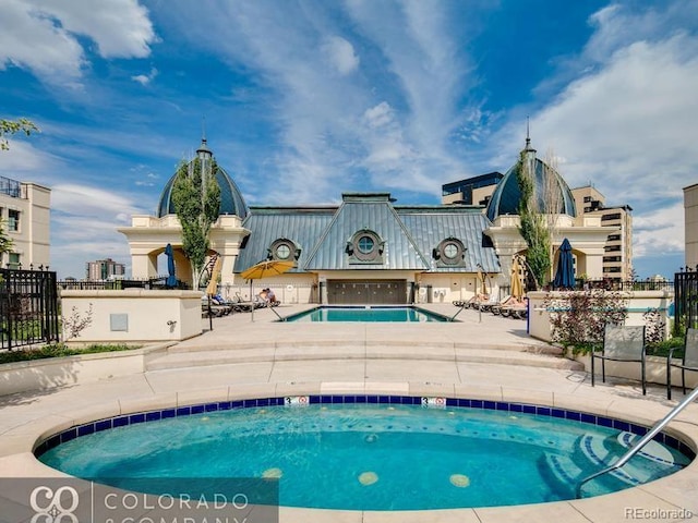 community pool with a patio area and fence