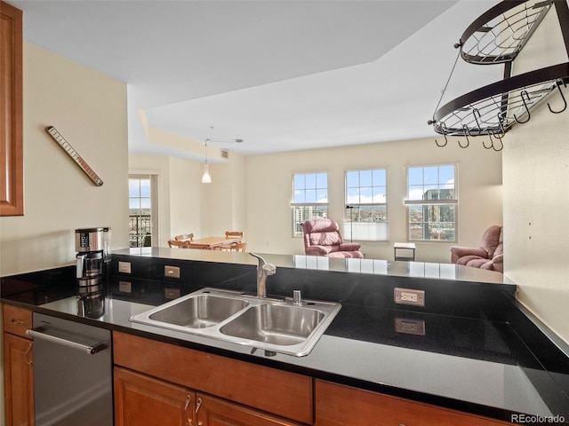 kitchen featuring a sink, plenty of natural light, dark countertops, and open floor plan