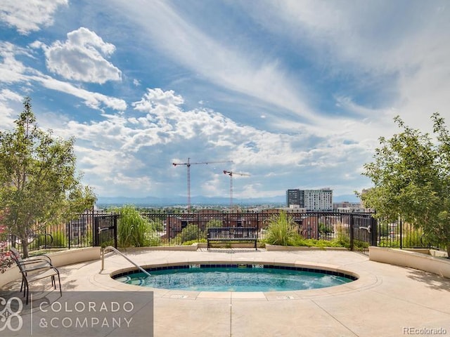 view of swimming pool with a hot tub