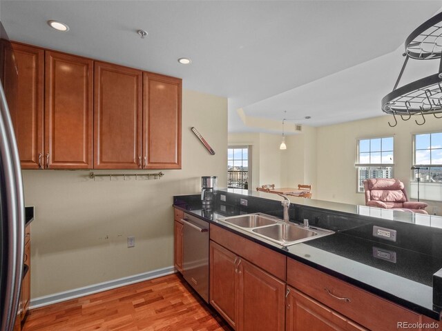 925 N Lincoln St Unit 12G, Denver, CO 80203 - kitchen featuring brown cabinets, appliances with stainless steel finishes, a sink, light wood finished floors, and baseboards