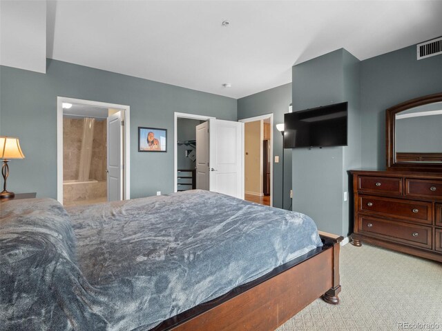 925 N Lincoln St Unit 12G, Denver, CO 80203 - bedroom with baseboards, ensuite bathroom, light colored carpet, and visible vents