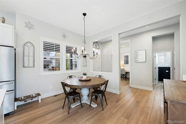 dining room with baseboards, a notable chandelier, and light wood-style flooring