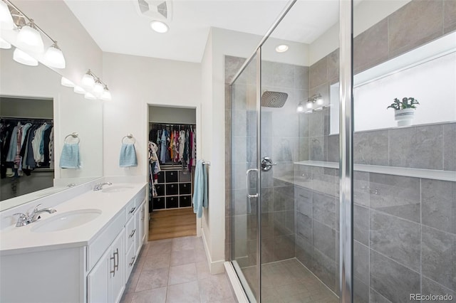 bathroom featuring visible vents, a sink, tile patterned flooring, and a stall shower