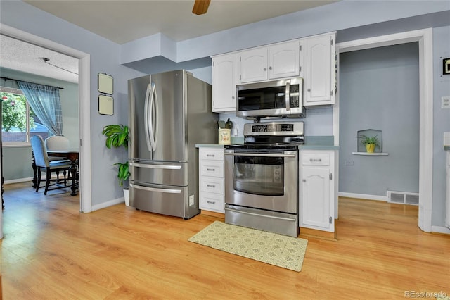 kitchen featuring baseboards, appliances with stainless steel finishes, light wood-type flooring, and white cabinets