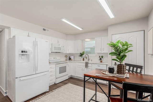 kitchen featuring white appliances, white cabinets, sink, dark hardwood / wood-style floors, and tasteful backsplash