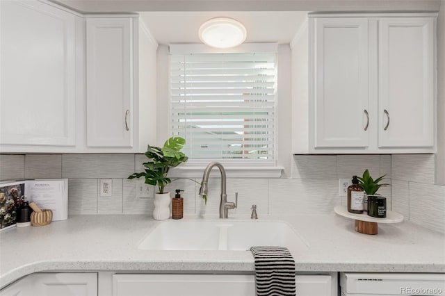 kitchen featuring white cabinets, backsplash, white dishwasher, and sink