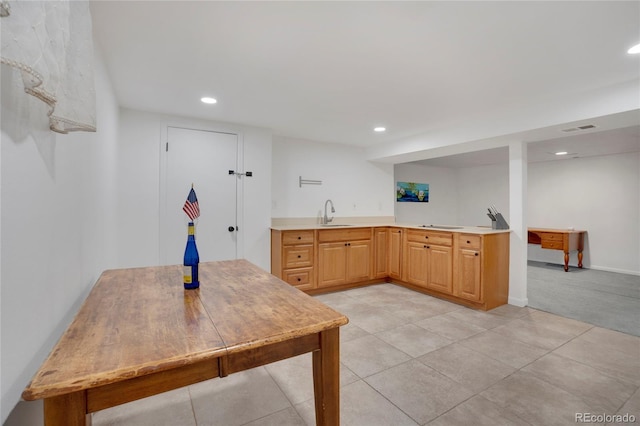 kitchen with light tile patterned floors, recessed lighting, light countertops, visible vents, and a sink