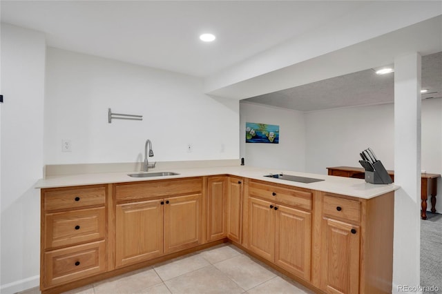 kitchen with light tile patterned floors, black electric stovetop, a peninsula, a sink, and light countertops